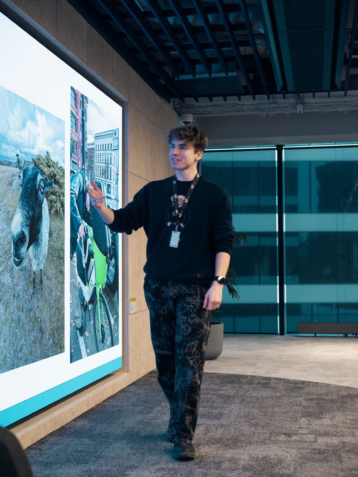 Jakub Siuda presenting photographs on a large display at 42 Warsaw