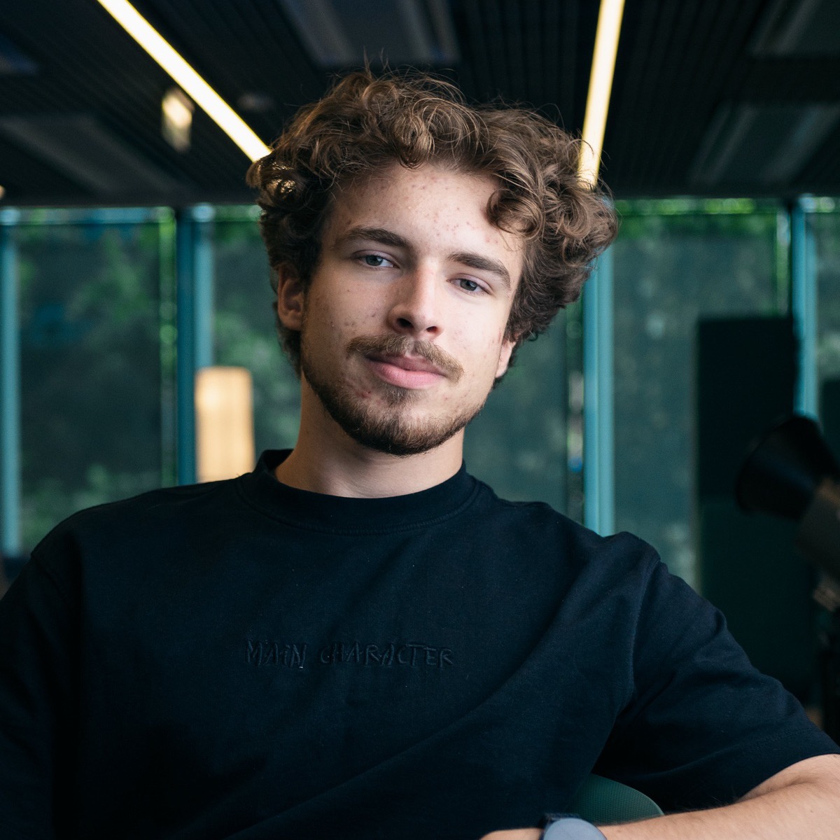 Portrait of Jakub Siuda seated indoors